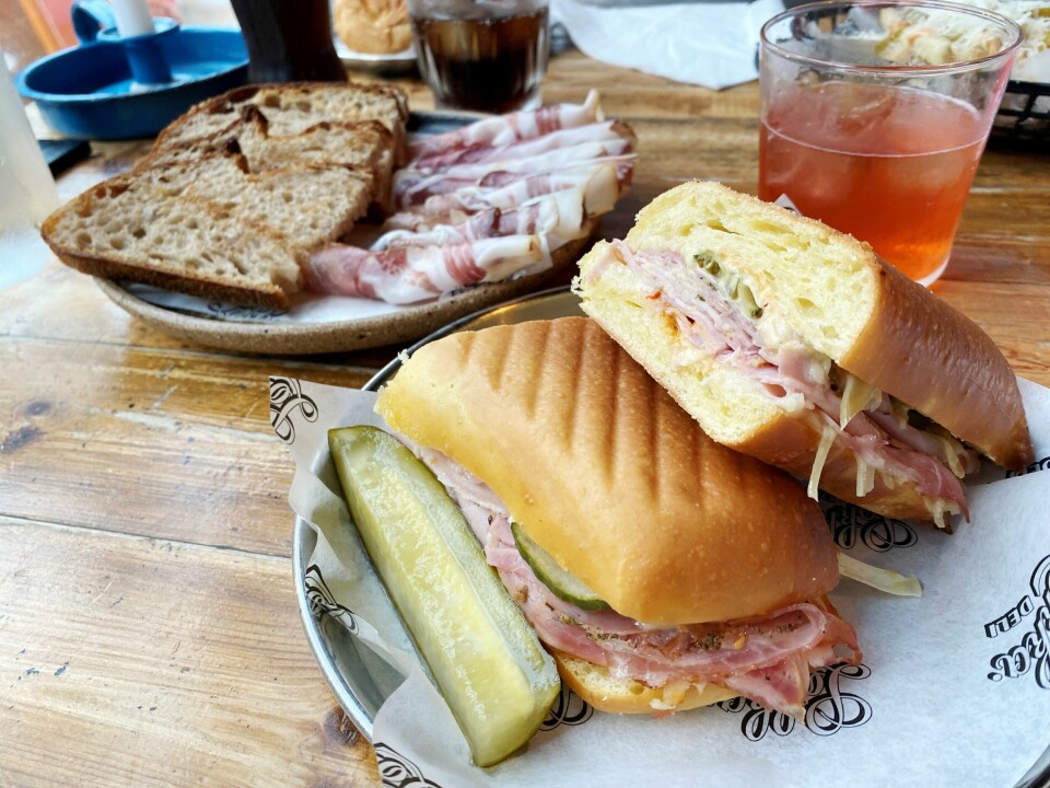 En saftig og sprø Cubano i forkant, med knasende surdeigsbrød og skinke bak.