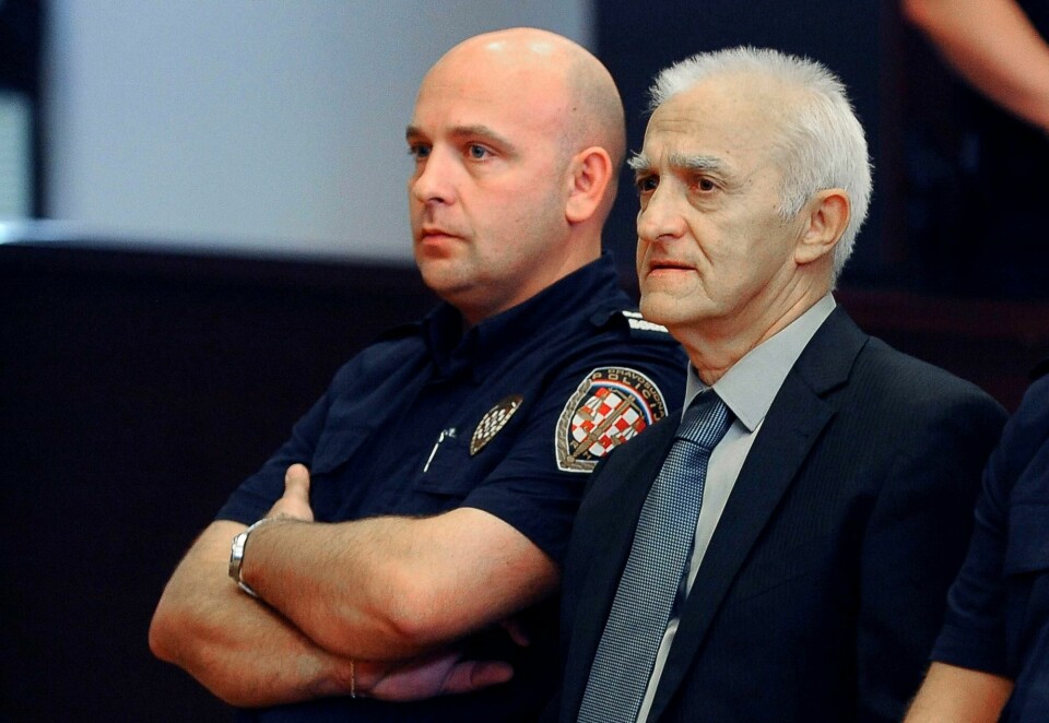 Dragan Vasiljkovic, bedre kjent som «kaptein Dragan», har sonet ferdig dommen han fikk for å ha torturert og drept sivile og krigsfanger under krigen i Kroatia. Nå leder han en kampanje for å få benådet og løslatt mannen som i 2003 drepte Serbias reformvennlige statsminister Zoran Djindjic. In this Tuesday, Sept. 20, 2016 file photo, Dragan Vasiljkovic, right, a former Serb paramilitary commander, sits next to a guard in a courtroom at the beginning of his trial in Split, Croatia. The municipal court has sentenced Vasiljkovic to 15 years in prison for war crimes in the 1990s Tuesday, Sept. 26, 2017. In the verdict it said that Vasiljkovic, also known as Captain Dragan and Daniel Snedden, is guilty of the killings and torture of imprisoned civilians and Croatian troops while he was a rebel Serb commander during the 1991-95 war in Croatia. (AP Photo, FILE)