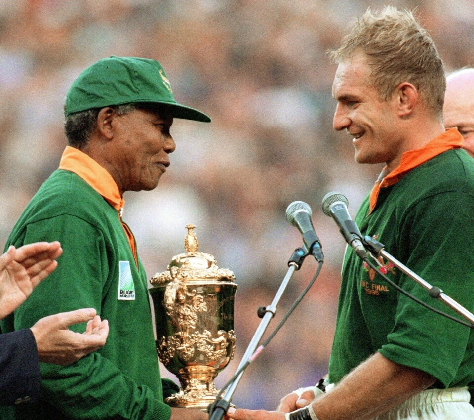 Sør-Afrikas president overrekker rugbylandslagets kaptein Francois Pienaar VM-pokalen etter finaleseieren i Johannesburg. Nelson Mandela