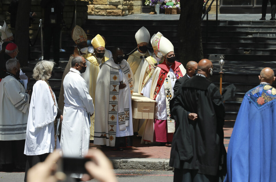 Desmond Tutu ble gravlagt i Cape Town. Den enkle furukisten med Desmond Tutu ble båret ut av katedralen i Cape Town etter bisettelsen lørdag. Foto: Nardus Engelbrecht / AP / NTB