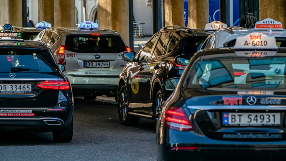 Regjeringen ønsker å innføre en prøveordning med makspris på taxier i byene. Et forslag om dette skal sendes ut på høring. Konkurransetilsynet føreslår å endre maksimalprisane for løyvepliktig drosjetransport. Bildet viser drosjar frå ulike selskap på haldeplassen utanfor Oslo S. Foto: Heiko Junge / NTB / NPK