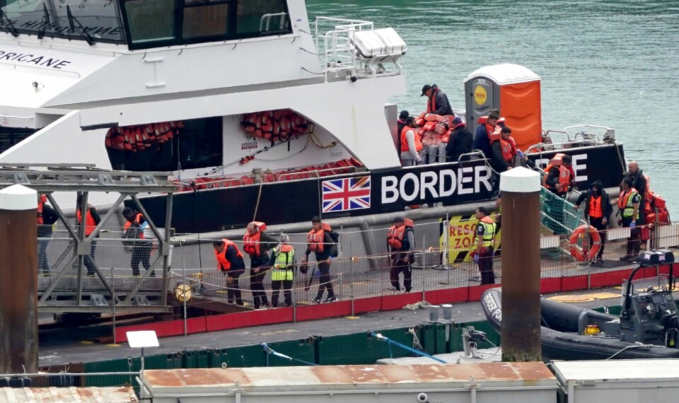 En gruppe flyktninger og migranter ankommer Dover etter å ha blitt plukket opp fra en liten båt i Den engelske kanal mandag. En gruppe flyktninger og migranter ankommer Dover etter å ha blitt plukket opp fra en liten båt i Den engelske kanal mandag. Foto: Gareth Fuller / PA via AP / NTB