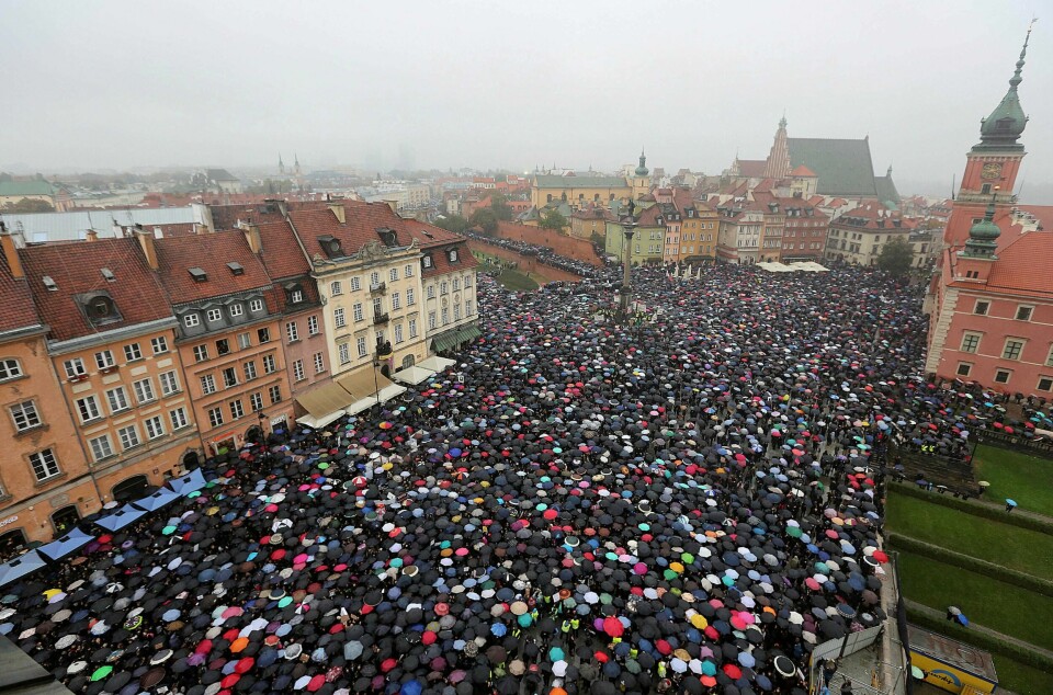 PARAPLYREVOLUSJONEN: Pøsregn var ikke til hinder da polakene strømmet til gatene for å protestere mot forslaget om å stramme inn på en allerede streng abortlov i Polen.FOTO: CZAREK SOKOLOWSKI/NTB SCANPIX