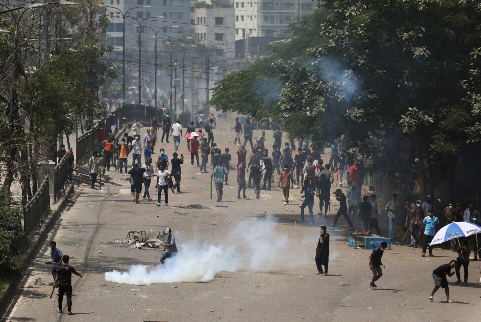 Lov og orden er gjenopprettet i Bangladesh etter flere dager med blodige opptøyer, melder landets hærsjef. Studenter og opprørspoliti i Bangladeshs hovedstad Dhaka. Foto: Rajib Dhar / AP / NTB