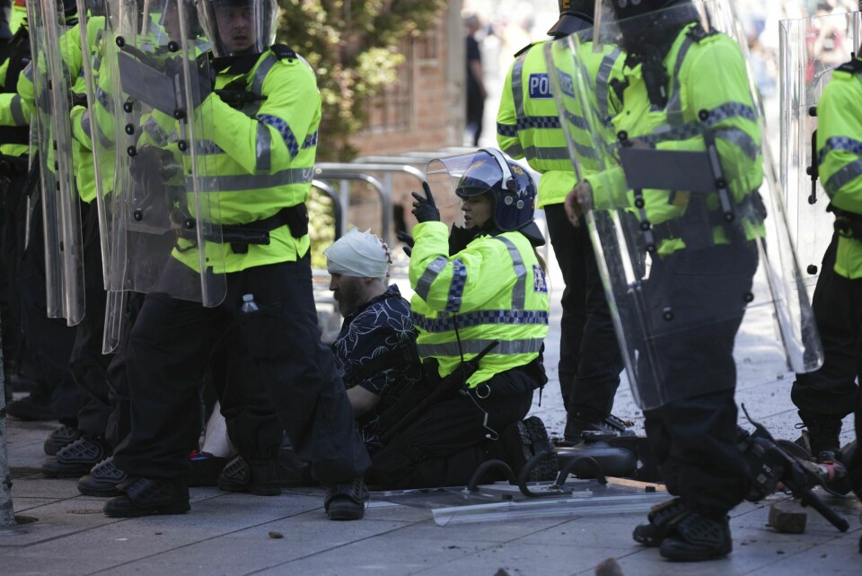 Politi og helsepersonell tar hånd om en skadet person under en protest i Liverpool lørdag. Det meldes om opptøyer i flere britiske byer. Politi og helsepersonell tar hånd om en skadet person under en protest i Liverpool lørdag. Det meldes om opptøyer i flere britiske byer. Foto: James Speakman / AP / NTB