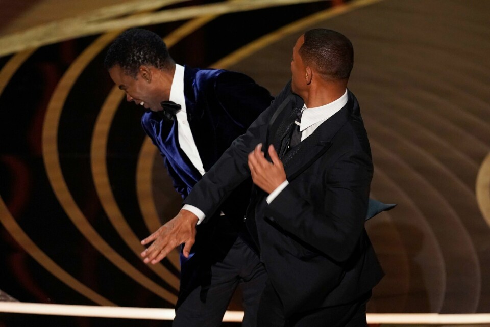 Netflix setter en actionfilm med Will Smith på pause, noe som kan ha noe med denne lusingen han ga Chris Rock under Oscar-utdelingen natt til mandag. Will Smith gikk opp på scenen og fiket til Chris Rock etter en vits om kona Jada Pinkett Smith. Foto: Chris Pizzello / AP / NTB