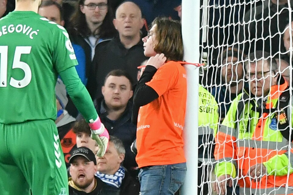 I en t-skjorte med påskriften «Just Stop Oil», fikk denne klimaaksjonisten midlertidig stanset fotballkampen mellom Premier League-lagene Everton og Newcastle 17. mars, da han stripset seg fast til den ene målstanga. I en t-skjorte med påskriften «Just Stop Oil», fikk denne klimaaksjonisten midlertidig stanset fotballkampen mellom Premier League-lagene Everton og Newcastle 17. mars, da han stripset seg fast til den ene målstanga.