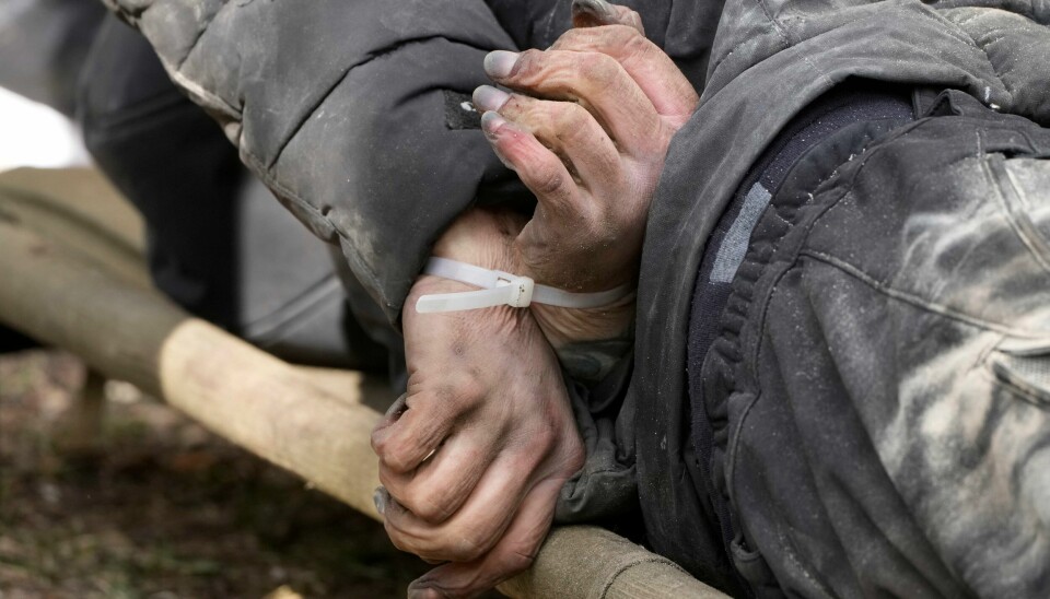 En bakbundet drept sivilist blir fraktet bort fra gatene i Butsja i Ukraina. En bakbundet drept sivilist blir fraktet bort fra gatene i Butsja i Ukraina.