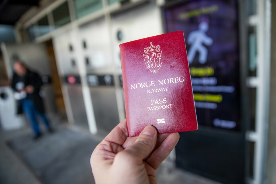 Mange skal skaffe seg nytt pass før sommeren, og politiet oppfordrer dem som ikke trenger pass, til å vente med å få seg et nytt. Bildet er av en hånd som holder et rødt norsk pass. Foto: Håkon Mosvold Larsen / NTB