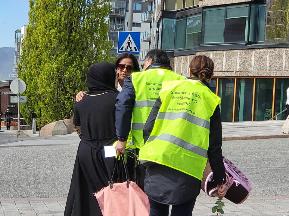 Her tar frivillige tak og roer ned personer under Sian demonstrasjon. Sian