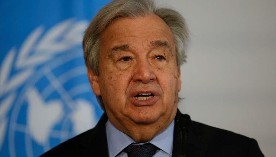 FNs generalsekretær António Guterres. Bildet er av FNs generalsekretær António Guterres. Han har på dress. Det er et blått FN-flagg i bakgrunnen. Det er et hvitt omriss av verdens kontinenter på flagget. De er omgitt av en laurbærkrans. Foto: Theresa Wey / AP / NTB