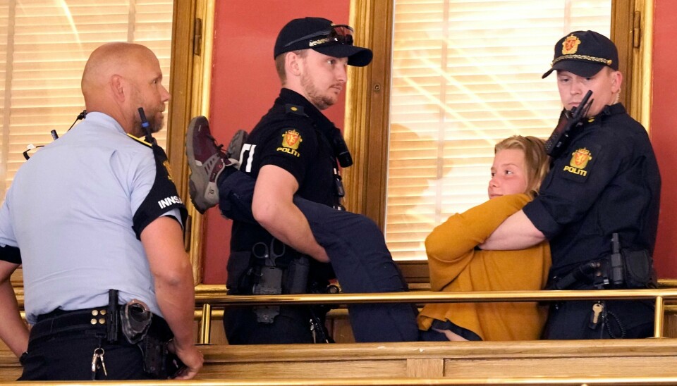 Aktivister tilknyttet Extinction Rebellion aksjonerte onsdag på innsiden av Stortinget. De ropte ut sitt budskap og limte seg fast med superlim. En klimaaktivist fra gruppen Extinction Rebellion ble fjernet av politiet på Stortinget onsdag. Foto: Heiko Junge / NTB