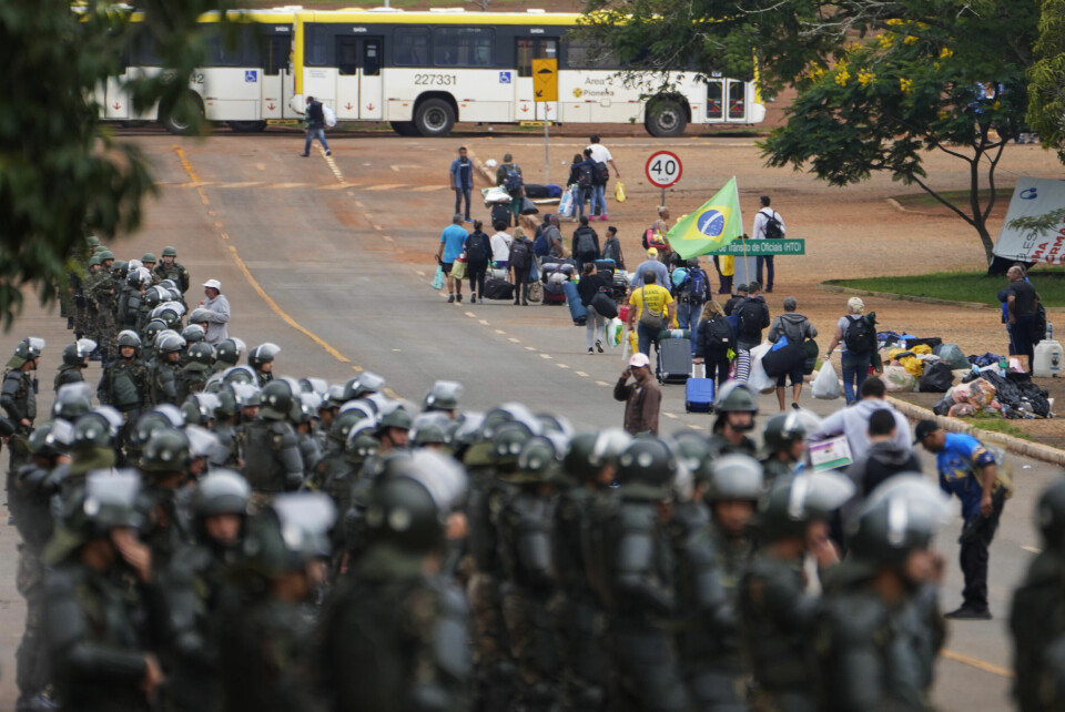 Politibetjenter holder vakt mens Bolsonaro-tilhengere forlater en leir i Brasilia mandag. Politibetjenter holder vakt mens Bolsonaro-tilhengere forlater en leir i Brasilia mandag.