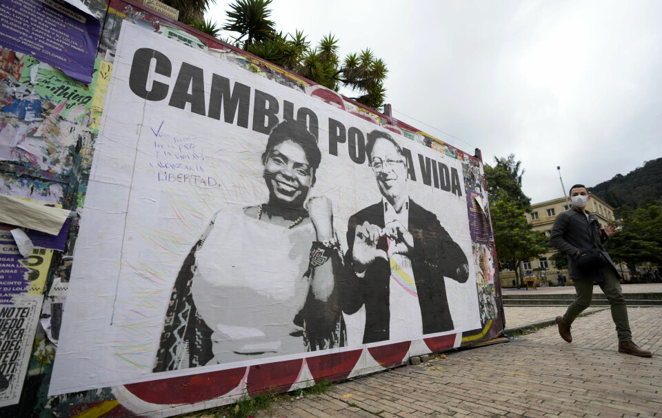 'Endring for livet' står det på valgkampplakaten til venstresidas Gustavo Petro og visepresidentkandidat Francia Marquez. En mann går foran en valgkampplakat i Bogota, Colombia.