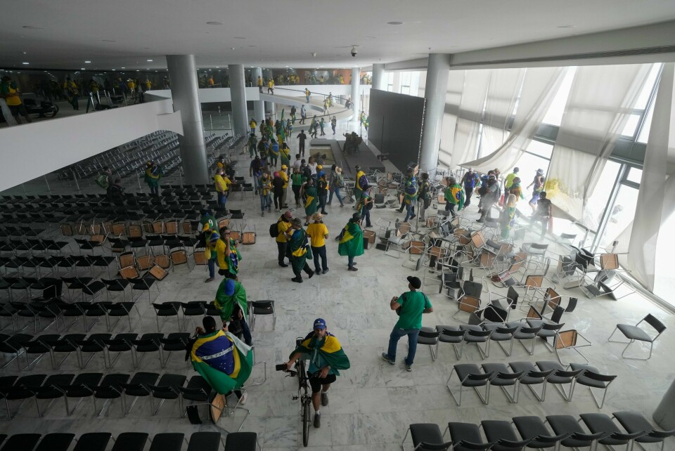 Bilder på TV-kanalen Globo viste demonstranter som streifet rundt i presidentpalasset, mange av dem iført grønt og gult, fargene til det brasilianske flagget. Bilder på TV-kanalen Globo viste demonstranter som streifet rundt i presidentpalasset, mange av dem iført grønt og gult, fargene til det brasilianske flagget. Foto: Eraldo Peres / AP / NTB
