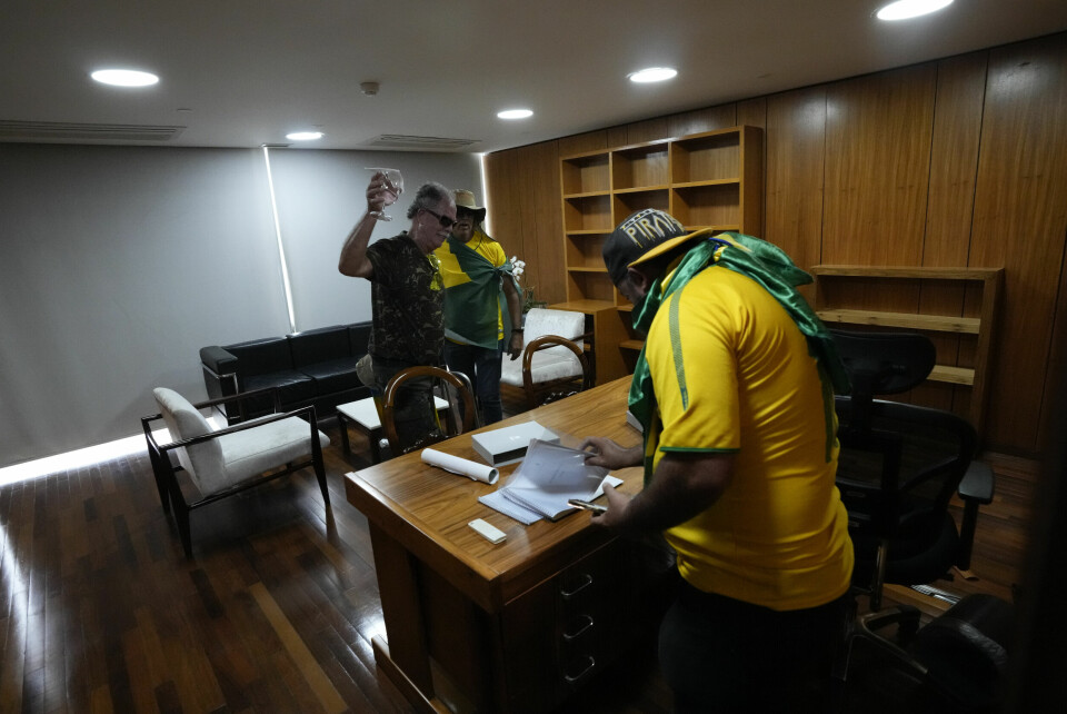 Demonstranter går gjennom papirer på et av kontorene i Planalto-palasset, kontoret til den brasilianske presidenten. Demonstranter går gjennom papirer på et av kontorene i Planalto-palasset. Foto: Eraldo Peres / AP / NTB