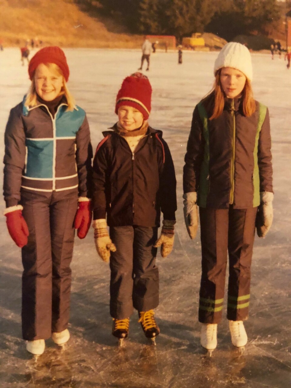 På Brakerøyabanen i lav vintersol. Det var ikke alltid snø, men frost og vanne-bil lagde is på skøytebanene. Her smiler vi pent til fotografen, min venninne og jeg og lillebroren til en annen venninne. Skøytebanen i drammen