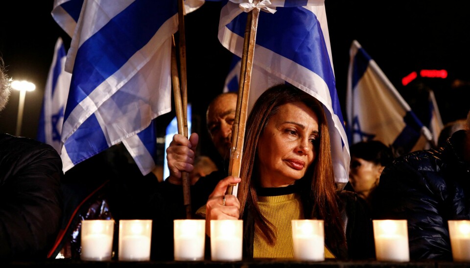 Israelske demonstranter stanset protestene for et minutts stillhet for å respektere de døde etter synagogeangrepet fredag. Demonstrantene hadde samlet seg for å protestere mot Benjamin Netanyahu og hans ytre høyre-regjerings angrep på den israelske rettsstaten. Israelis stand for a minute of silence in recognition of a deadly shooting attack that took place on January 27, 2023, during a demonstration against proposed judicial reforms by Israel's new right-wing government, in Tel Aviv, Israel January 28, 2023. REUTERS/Corinna Kern