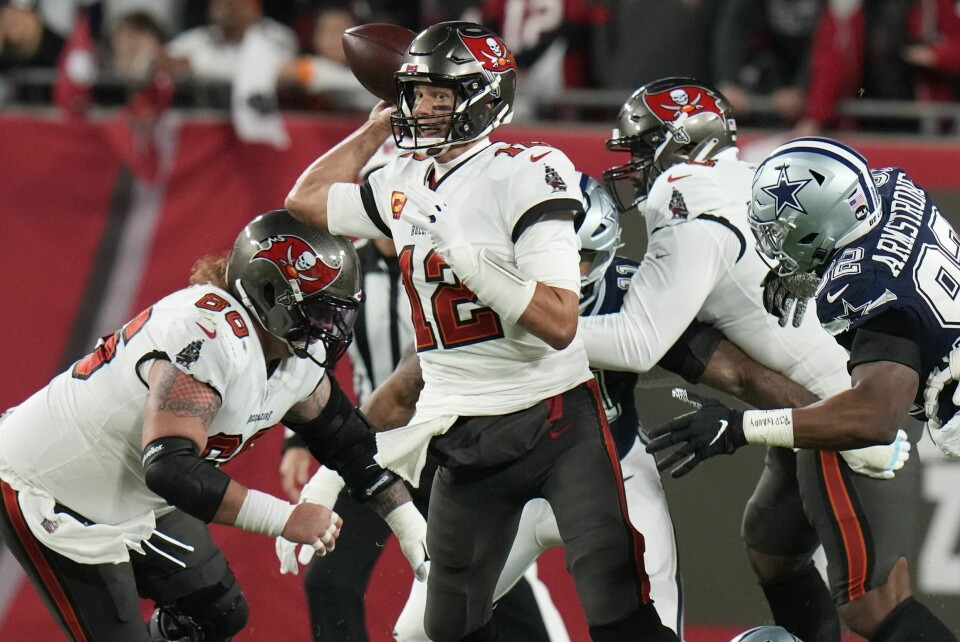 Quarterbackstjernen Tom Brady har bestemt seg for å avslutte sin aktive NFL-karriere for godt. Tom Brady prøver en pasning under hardt press i sluttspillkampen mot Dallas Cowboys. Tampa Bay Buccaneers tapte klart i det som kan ha vært quarterbacklegendens siste kamp. Foto: Chris O'Meara, AP / NTB