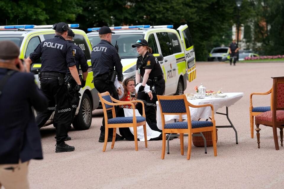 En bunadskledd demonstrant blir båret bort av politiet. En bunadskledd demonstrant blir båret bort av politiet. Foto: Lise Åserud / NTB