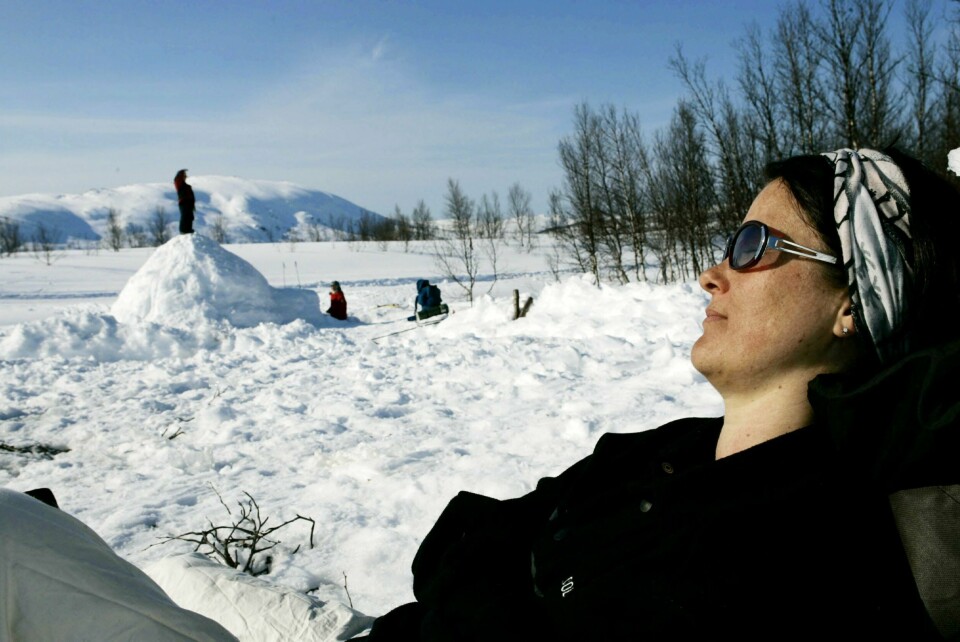 Påskeferie, slik mange drømmer om. TROMSØ 20060412:
Onsdag var det strålende påskevær i Tromsø. Kvinne soler seg, mens barna leker i snøen i bakgrunnen.
FOTO: TOR RICHARDSEN / NTB