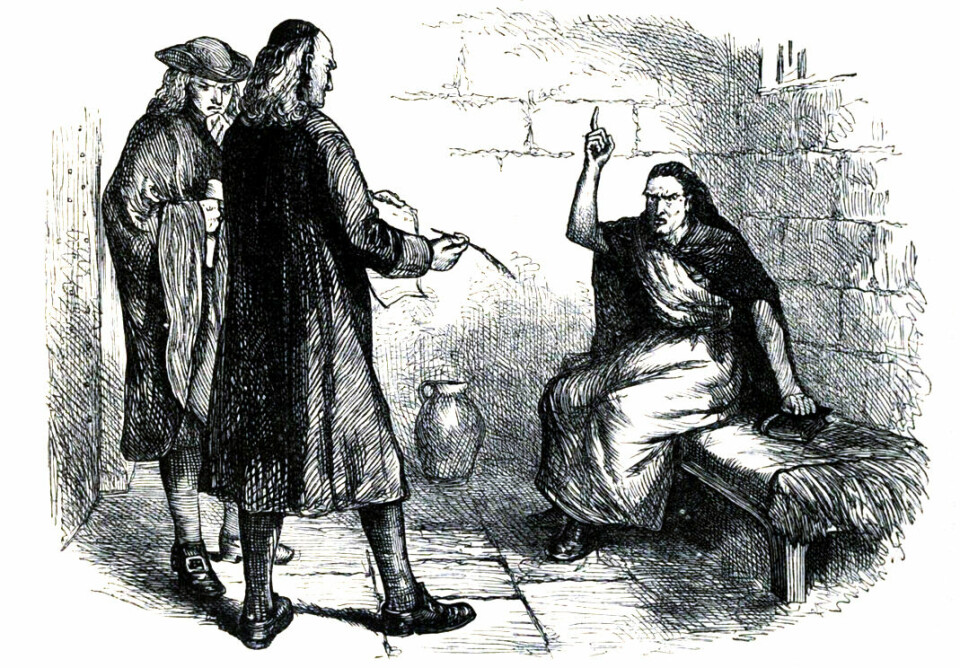 I Vardøhus fikk Anna Rhodius en aktiv rolle i å instruere de trolldomsanklagete kvinnene hvordan de skulle bekjenne i tråd med nye kontinentale ideer om demonologi. Illustrasjon av hekseprosessen i Salem 1692. To menn står og ser på en dame som sitter på en benk i en fengselscelle.