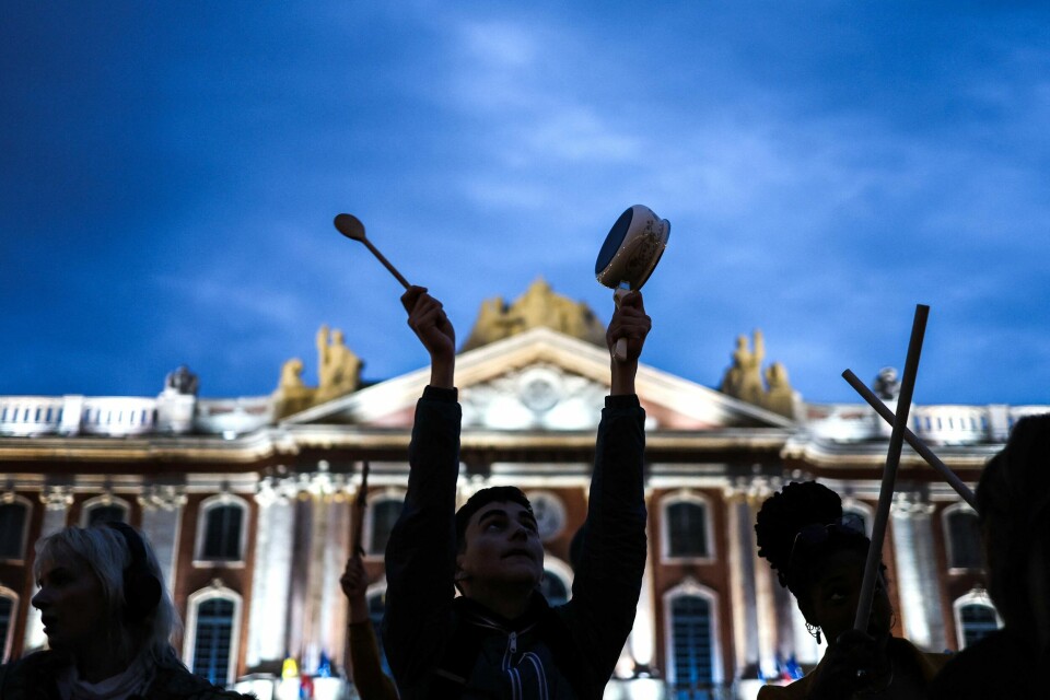 En demonstrant slår på en kasserolle under en protest i Toulouse. Protestene var på årsdagen ett år etter at Emmanuel Macron ble gjenvalgt som Frankrikes president. De siste månedene har Macron stått overfor omattende protester i forbindelse med en omstridt pensjonsreform. En demonstrant slår på en kasserolle under en protest i Toulouse.
