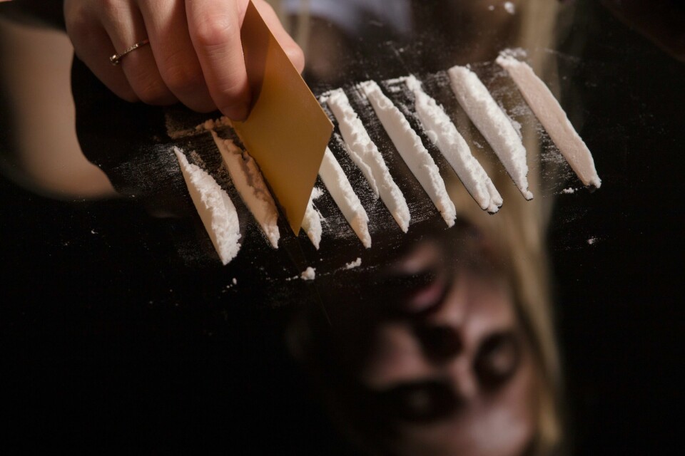 – Vi skremmes av rapporter om normalisering av kokain og MDMA, og det kan virke som ingen egentlig vet hvordan dette kan bremses, skriver kronikkforfatteren. cocaine or other drugs cut with card on mirror with female reflection, hand dividing white powder narcotic