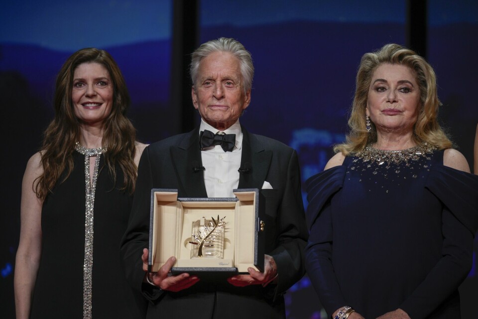 Michael Douglas holder ærespalmen, med Chiara Mastroianni (til venstre) og Catherine Deneuve ved sin side. Michael Douglas holder ærespalmen, med Chiara Mastroianni (til venstre) og Catherine Deneuve ved sin side.