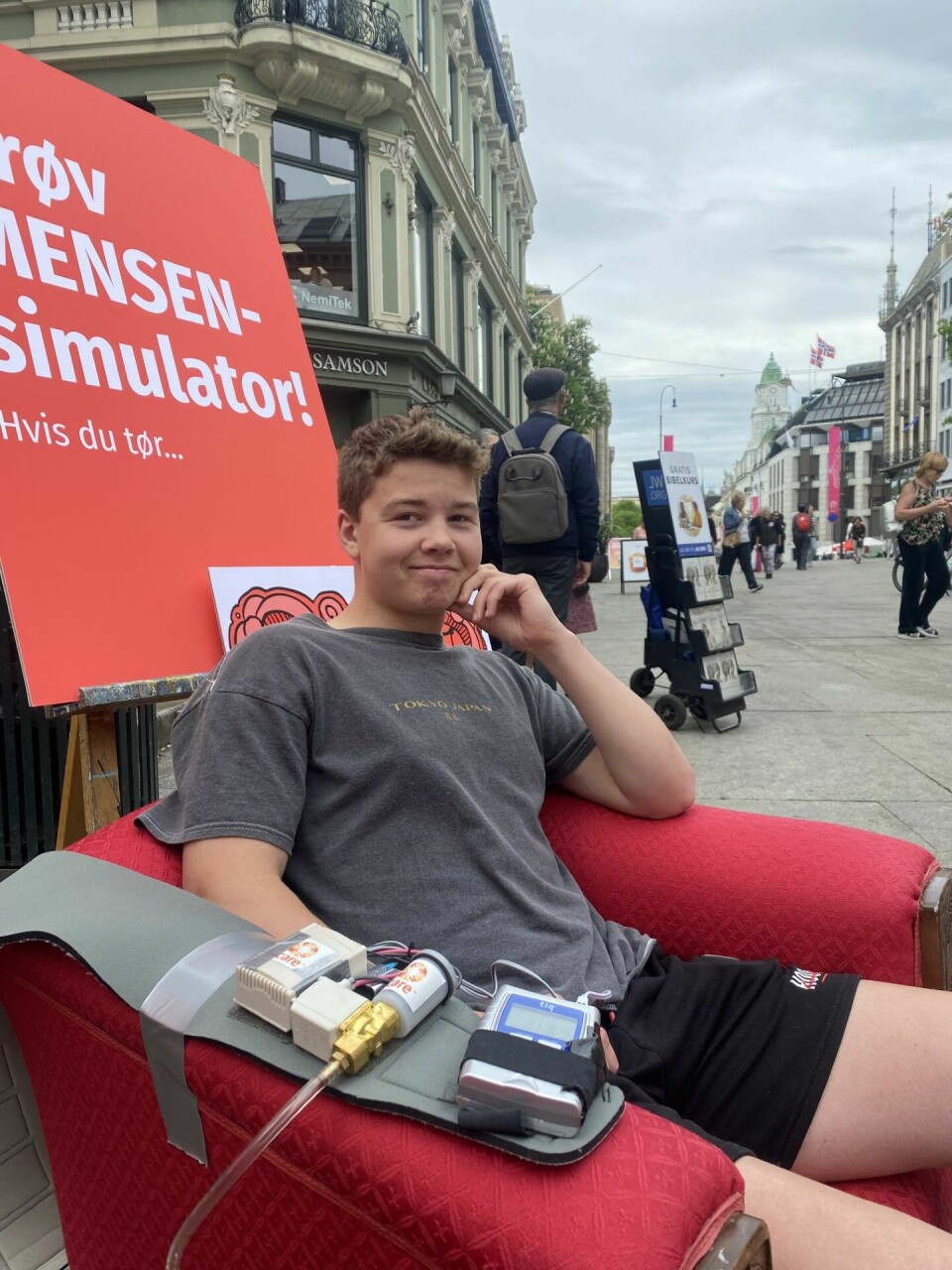 Kasper Kjær Jørgensen (20) tror ikke han hadde orket å gå på skolen med kraftige menssmerter. En ung gutt sitter i en rød stol og prøver en mensen-simulator.