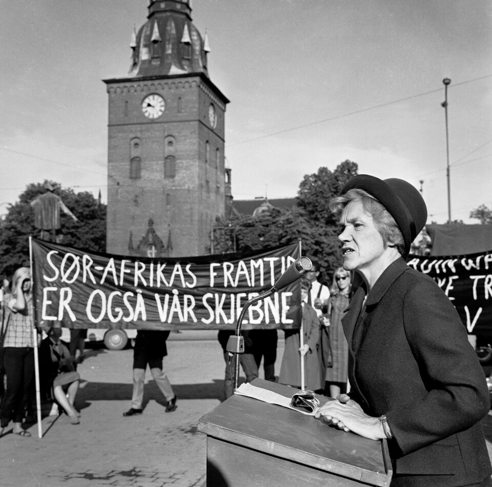 Støttedemonstrasjon for den fengslede ANC-lederen, Nelson Mandela på Stortorget 12. juni 1964. Stortingsrepresentant Aase Lionæs taler. Banneret viser «Sør-Afrikas framtid er også vår skjebne». En dame taler til demonstrantene.