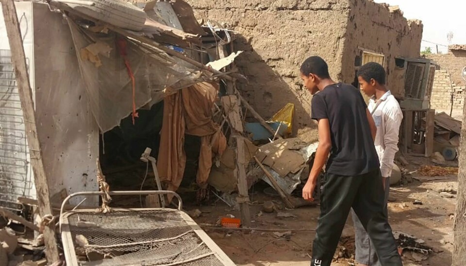 Innbyggere i Khartoum undersøker boligen sin etter at den ble ødelagt i et angrep Sudanere ser på restene av huset sitt etter angrep på bydelen Allamat i Sudans hovedstad Khartoum. Foto: AP / NTB