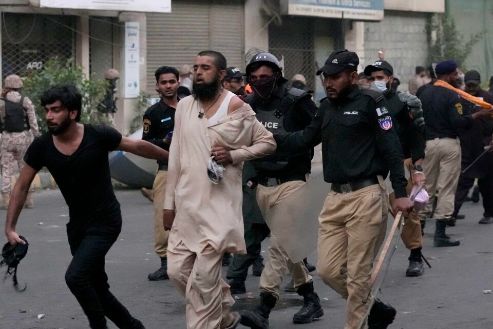 Pakistansk politi pågriper en islamist under opptøyene i Karachi søndag. Pakistansk politi pågriper en islamist under opptøyene i Karachi søndag. Foto: Fareed Khan / AP / NTB