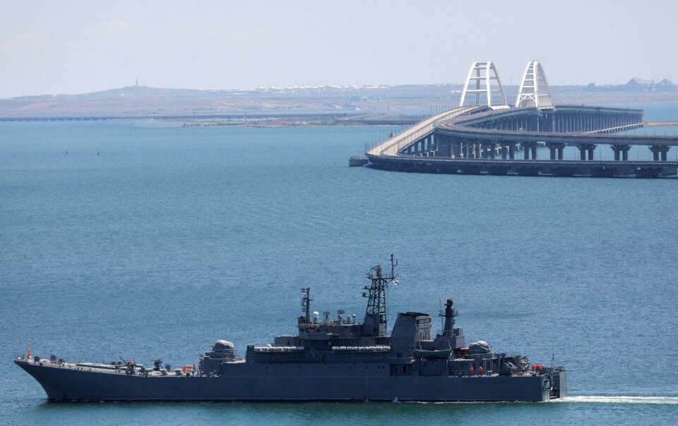 Et russisk krigsskip avbildet foran Kertsjbroen ved Krim i 2023. FILE PHOTO: A Russian Navy amphibious landing ship that was deployed to transport cars across the Kerch Strait, moves near the Crimean Bridge, a section of which was damaged by an alleged overnight attack, as seen from the city of Kerch, Crimea, July 17, 2023. REUTERS/Alexey Pavlishak/File Photo