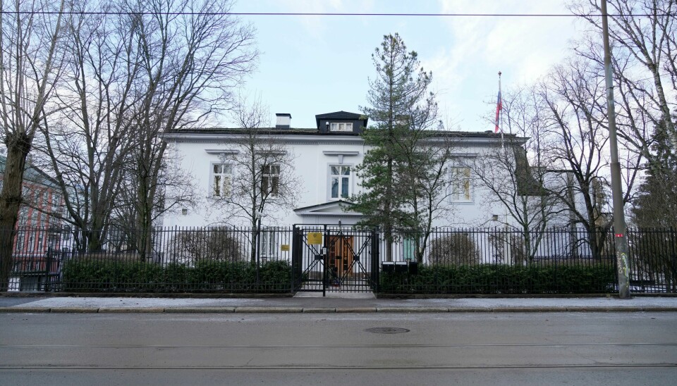 Russlands ambassade på Skillebekk i Oslo. Bildet er av den russiske ambassaden i Oslo. Bildet er tatt fra andre siden av gaten. Bygget er to etasjer høyt, har hvite vegger og sort tak. Bildet er fra i vinter. Det er mange løvtrær uten blader på bildet. Det russiske flagget henger rett ned, siden det er vindstille.Foto: Heiko Junge / NTB