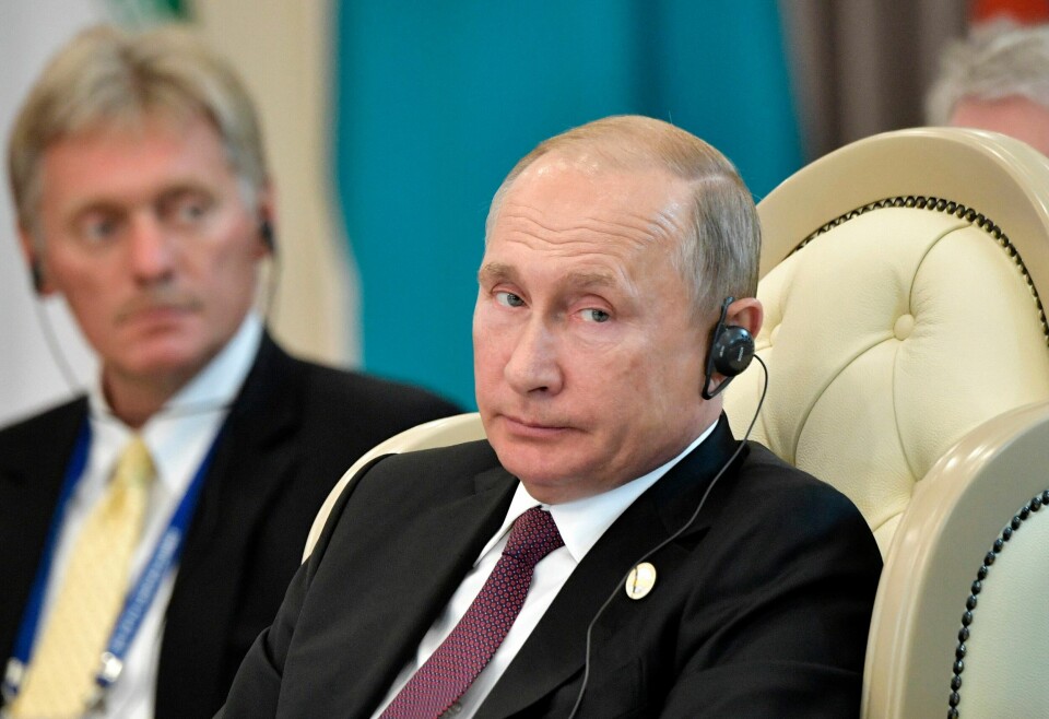 Vladimir Putin har vært president i Russland siden år 2000. Talsmann Dmitrij Peskov ses i bakgrunnen. Russian President Vladimir Putin and presidential spokesman Dmitry Peskov, left, attend a meeting during the 5th Caspian summit in Aktau, the Caspian Sea port in Kazakhstan, Sunday, Aug. 12, 2018. (Alexei Nikolsky, Sputnik, Kremlin Pool Photo via AP)