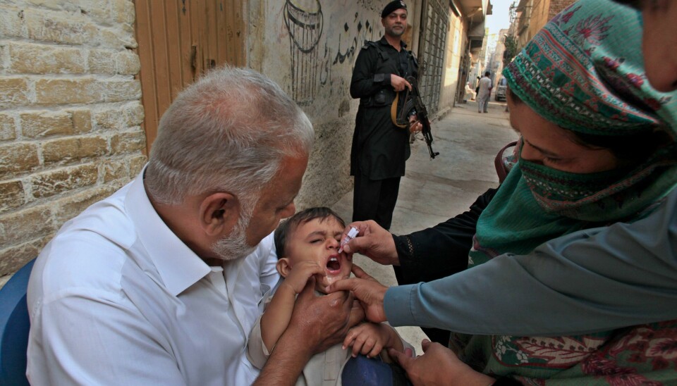 En politimann holder vakt i et nabolag i Peshawar mandag mens en helsearbeider gir et barn dråpene som skal beskytte det mot den smittsomme sykdommen polio. Fredagens angrep skjedde i byen Mastung i Balutsjistan. En politimann holder vakt i et nabolag i Peshawar mandag mens en helsearbeider gir et barn dråpene som skal beskytte det mot den smittsomme sykdommen polio. Fredagens angrep skjedde i byen Mastung i Balutsjistan. Foto: Mohammad Sajjad / AP / NTB