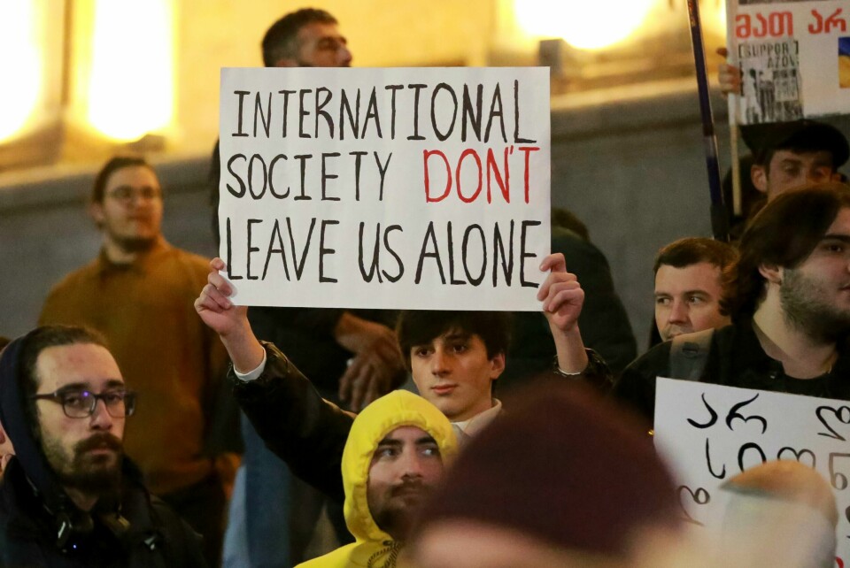 En demonstrant i Tbilisi med en plakat der verdenssamfunnet blir bedt om ikke å la Georgia i stikken. En demonstrant i Tbilisi med en plakat der verdenssamfunnet blir bedt om ikke å la Georgia i stikken. Foto: Zurab Tsertsvadze / AP / NTB