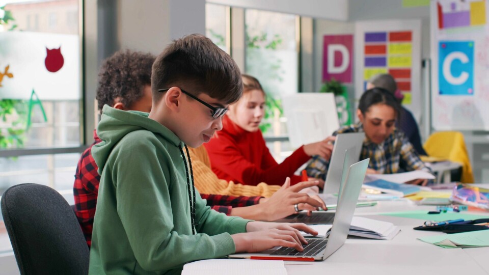 Digital dømmekraft og kompetanse er blant de viktigste ferdighetene vi kan lære dagens barn og unge. Skolene må få tillit til å gjøre dette på den måten som passer best for deres elever, skriver forfatterne av innlegget. Skoleelever med laptop, skjermbruk i skolen