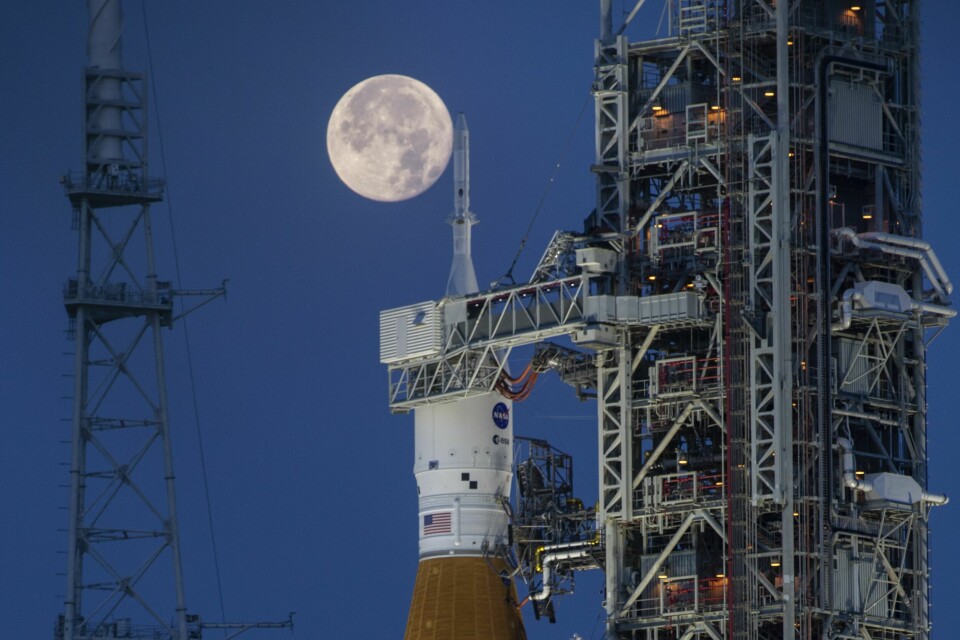Fra NASAs oppskytingssenter i Houston, Texas. Fullmånen lyser bak Artemis I og romfartøyet Orion i juni 2022. Romferdene Artemis II og III er utsatt, kunngjorde Nasa tirsdag. Foto: Cory Huston / NASA via AP / NTB