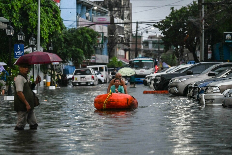 Klimaendringene kommer til å påvirke enda flere barn i årene som kommer. Her dytter en mann en båt med et barn gjennom oversvømmede gater i Manila på Filippinene. Her dytter en mann en båt med et barn gjennom oversvømmede gater i Manila på Filippinene.