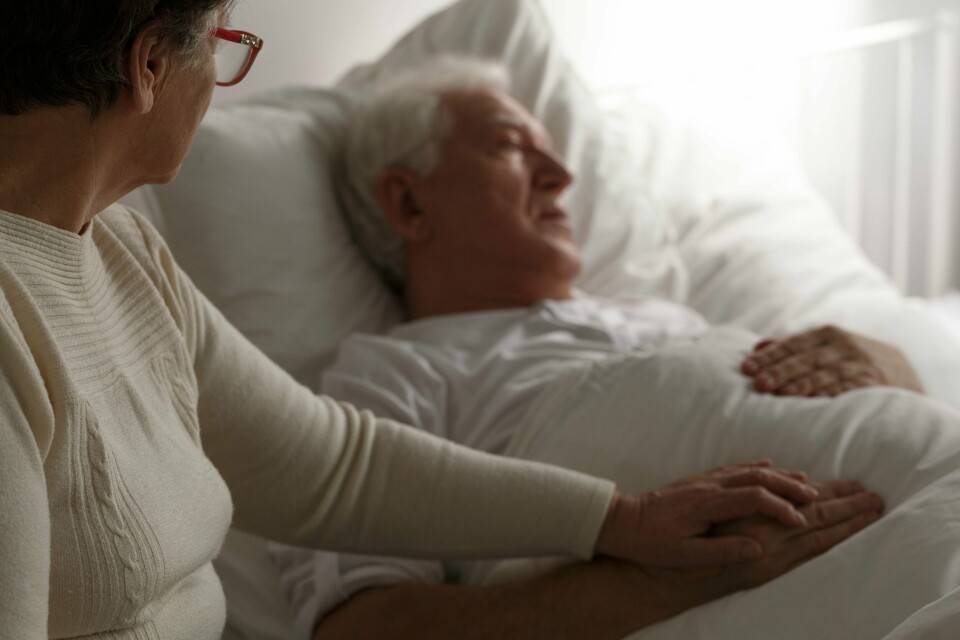 Hvorfor må vi betale for sykehjemsplass, men ikke for sykehusopphold? Å kalle pasientene «beboer» hjelper ikke, skriver Kristin Borg. Sad senior man in hospital bed and his wife sitting next to him