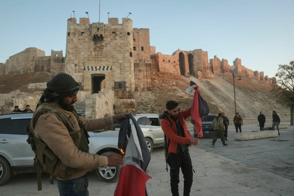 Syriske opprørere brenner syriske flagg ved gamlebyen i Aleppo. Syriske opprørere brenner syriske flagg ved gamlebyen i Aleppo.