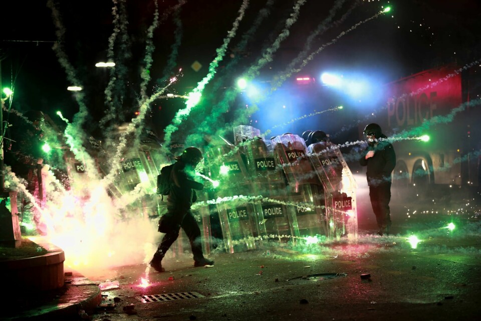 Demonstranter brukte fyrverkeri mot politiet som blokkerte en gate i Tbilisi natt til lørdag. Demonstranter brukte fyrverkeri mot politiet som blokkerte en gate i Tbilisi natt til lørdag.