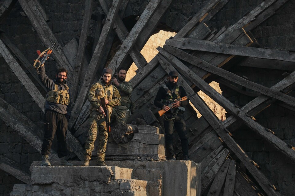 Opprørsstyrker i Hama, Syria, fredag 6. desember. Opprørere feirer erobringen av byen Hama fredag. Foto: Omar Albam / AP / NTB