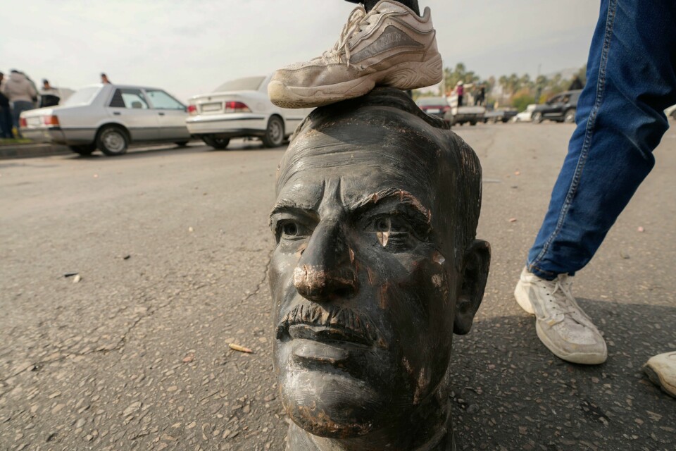 En opprører hviler foten på hodet av den ødelagte statuen av tidligere president Hafez Assad, far til Bashar al-Assad. En opprører hviler foten på hodet av den ødelagte statuen av tidligere president Hafez Assad, far til Bashar al-Assad. Foto: AP Photo/Hussein Malla/NTB
