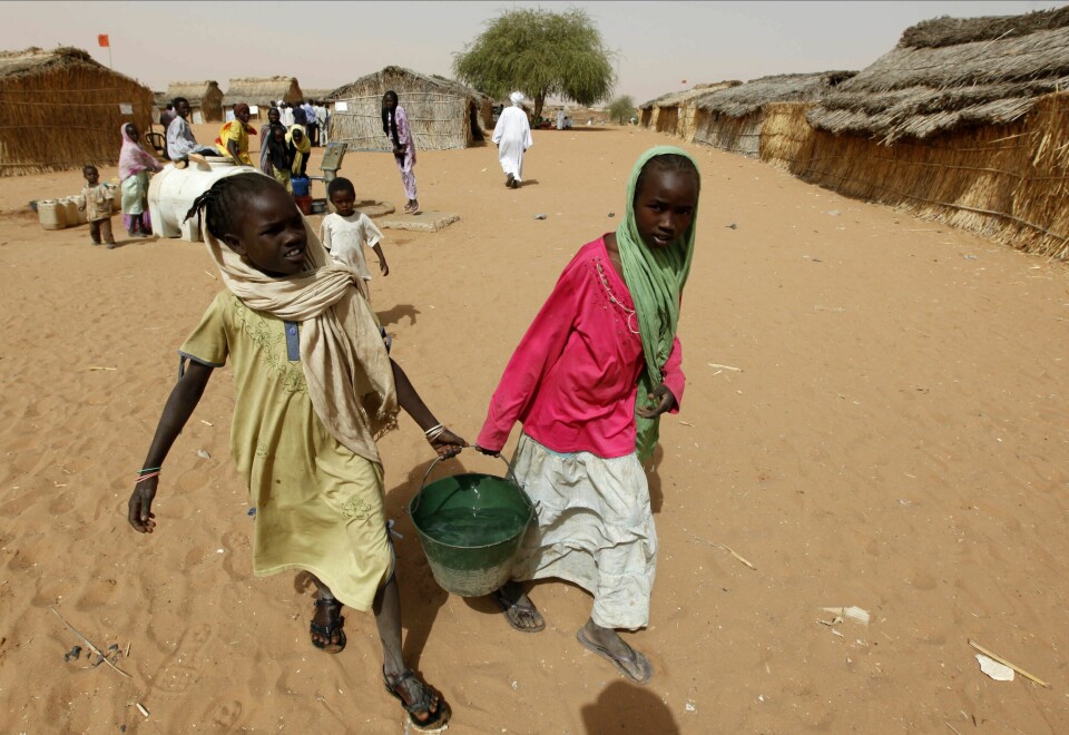 Sudanske flyktninger i leiren Zamzam i utkanten av storbyen El Fasher i Darfur. Byen som ble angrepet mandag, ligger cirka 18 mil herfra. Arkivfoto. Jenter som er drevet på flukt, bærer vann utenfor leiren Zamzam. Bildet er fra 2010. Leiren ligger i utkanten av byen El Fasher, den siste i Darfur som ikke kontrolleres av paramilitære styrker. Foto: Nasser Nasser / AP / NTB
