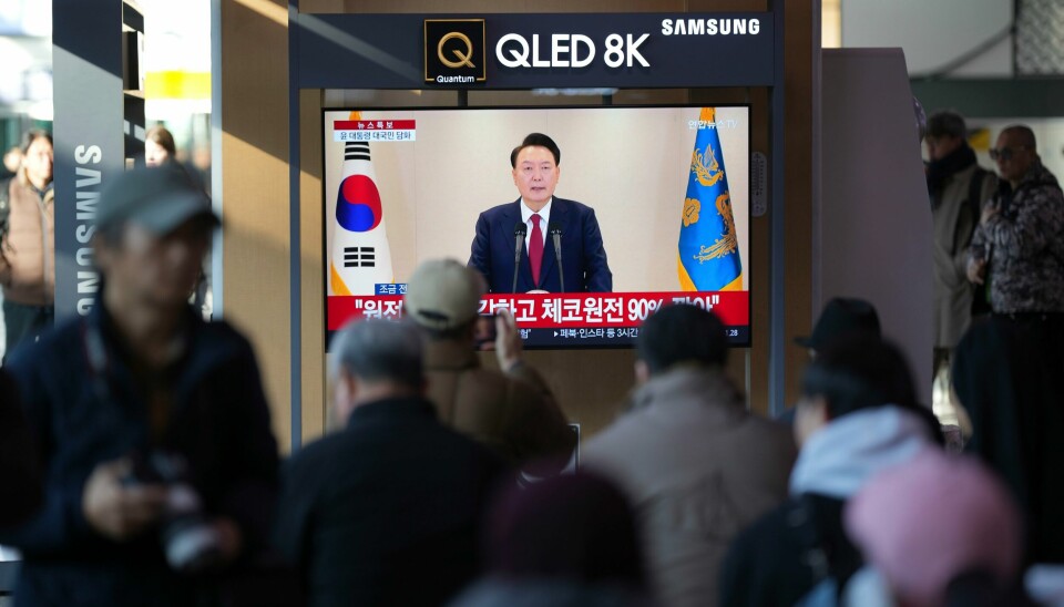 Folk på en jernbanestasjon i Seoul følger president Yoon Suk-yeols tale på TV. Folk på en jernbanestasjon i Seoul følger president Yoon Suk-yeols tale på TV. Foto: Lee Jin-man / AP / NTB