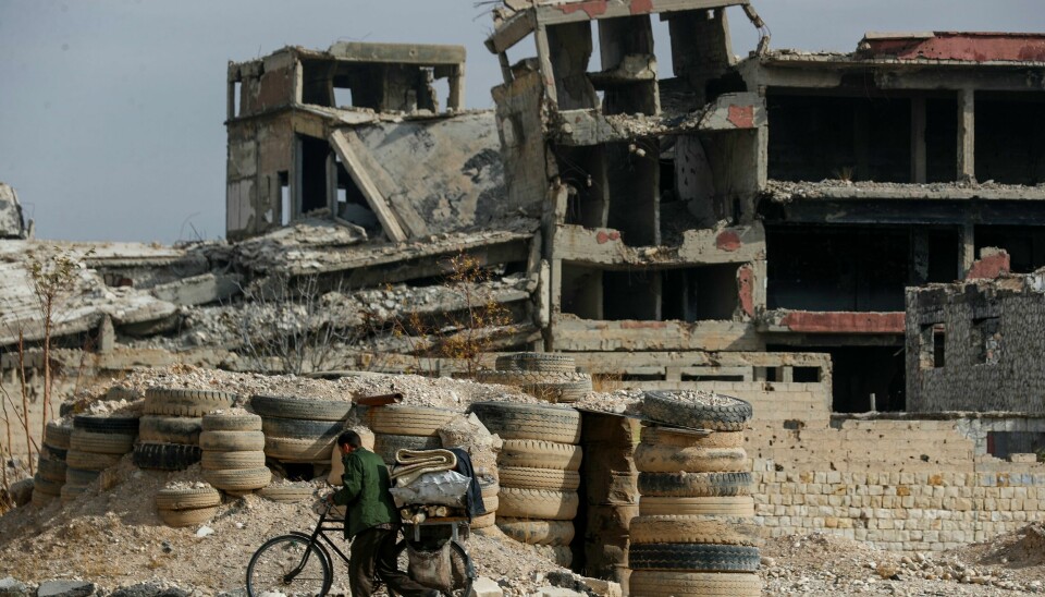 En syrisk mann med sykkel på vei forbi ødelagte bygninger i byen Harasta torsdag. En syrisk mann med sykkel på vei forbi ødelagte bygninger i byen Harasta torsdag. Foto: Omar Sanadiki / AP / NTB