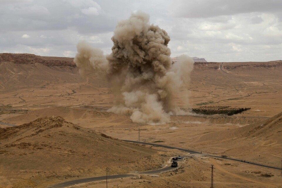 En støvsky stiger til værs etter en kontrollert detonasjon av en landmine i Palmyra i Syria på dette bildet tatt i april 2016. Et enormt antall udetonerte miner, klasebomber og andre eksplosiver ligger mange steder i Syria. En støvsky stiger til værs etter en kontrollert detonasjon av en landmine i Palmyra i Syria på dette bildet tatt i april 2016. Et enormt antall udetonerte miner, klasebomber og andre eksplosiver ligger mange steder i Syria. Arkivfoto: Hassan Ammar / AP / NTB